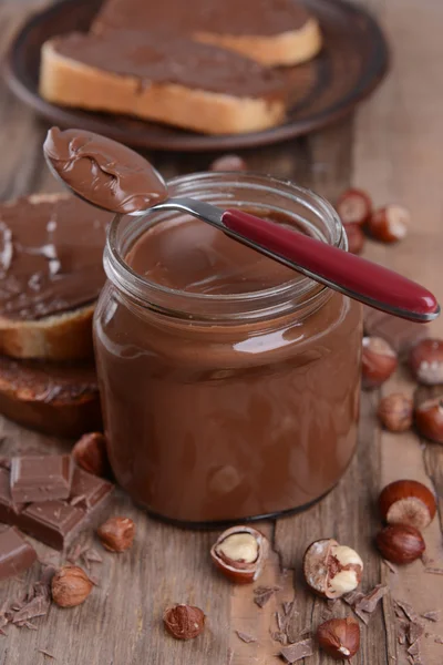 Sweet chocolate cream in jar on table close-up — Stock Photo, Image