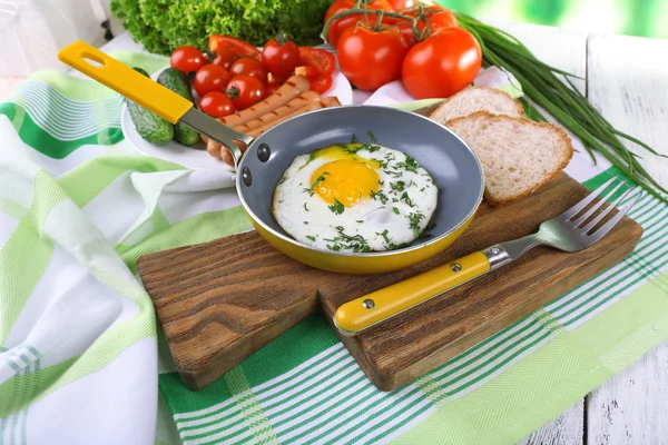 Яичница с колбасой и овощами подается на сковороде на доске — стоковое фото