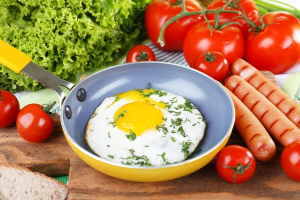 Ovo mexido com salsicha e legumes servidos na panela na tábua de corte — Fotografia de Stock