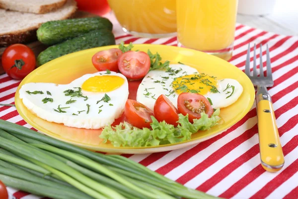 Huevos revueltos con verduras y jugos servidos en plato sobre servilleta —  Fotos de Stock