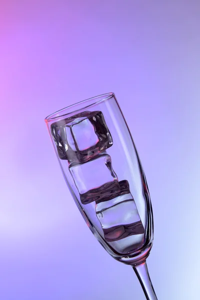 Glass with ice cubes on color background — Stock Photo, Image