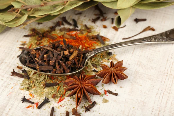 Bay leaves and seeds on green wooden background — Stock Photo, Image