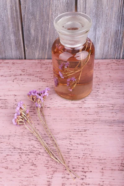 Bottle of herbal tincture and brunch of flowers — Stock Photo, Image