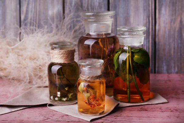 Bottles of herbal tincture on a napkin on  wooden table in front of wooden wall — Stock Photo, Image