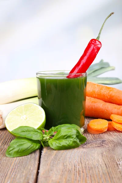 Świeże soki warzywne z szczypiorkiem, feferony na drewnianym stole i marchewki — Zdjęcie stockowe