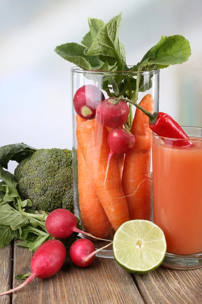 Fresh carrot juice with vegetables on wooden table — Stock Photo, Image