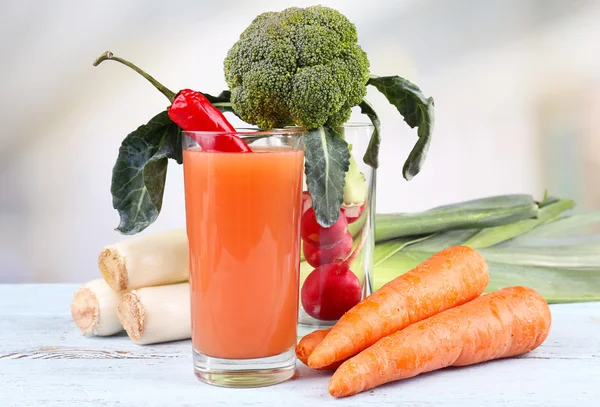 Verre de jus de carotte frais avec légumes sur table en bois — Photo