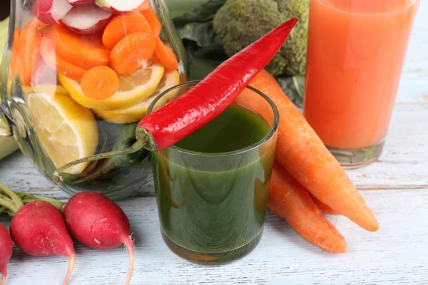 Pot de légumes coupés et verre de jus de légumes frais avec des légumes sur fond en bois — Photo