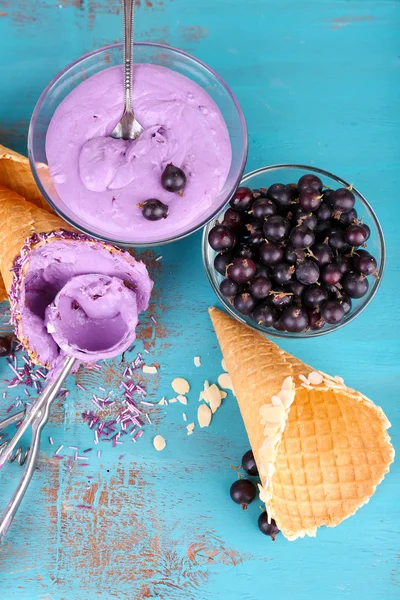 Tasty ice cream with fresh berries on old blue wooden table Stock Photo