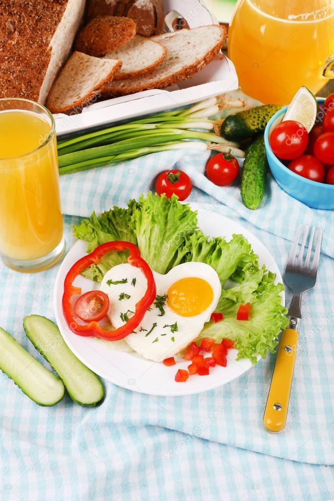 Scrambled egg with vegetables and juice served in plate on fabric background