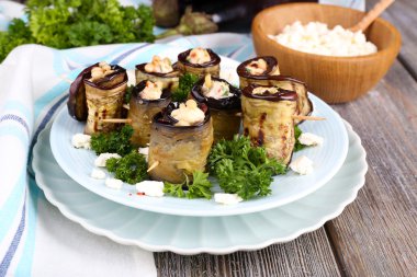 ahşap zemin üzerinde yuvarlak bir tabak içinde süzme peynir ile kızarmış patlıcan