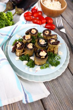 ahşap zemin üzerinde yuvarlak bir tabak içinde süzme peynir ile kızarmış patlıcan