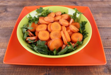 dilim havuçlu, kuzukulağı ve maydanoz ahşap zemin üzerine yeşil yuvarlak kase