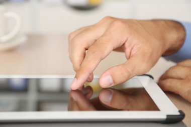 ahşap arka plan üzerinde tablet üzerinde çalışan adam