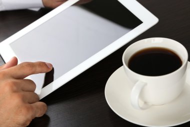 ahşap arka plan üzerinde tablet üzerinde çalışan adam