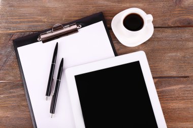 Tablet, fincan kahve, kalem ve kağıt üzerinde tahta arka plan ile klasör