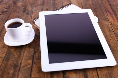 Tablet, fincan kahve ve ahşap zemin üzerinde dizüstü