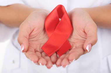 AIDS bilinçlendirme kırmızı kurdele üzerine beyaz izole elinde olan kadın
