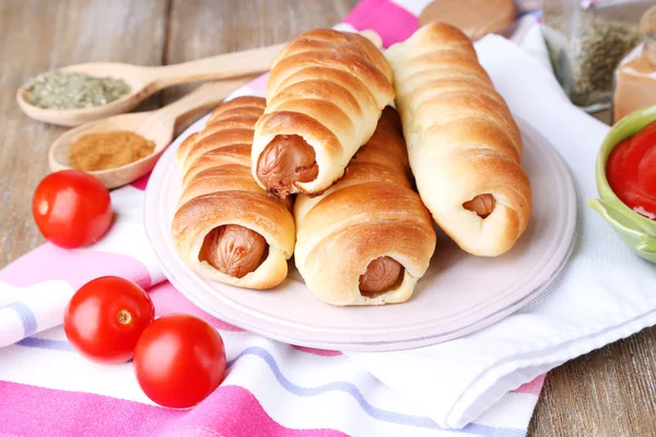 Pieczona kiełbasa rolki na tabliczce na stół szczegół — Zdjęcie stockowe