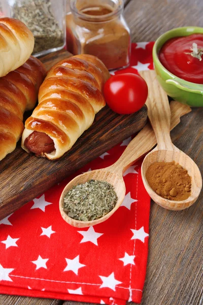 Baked sausage rolls on board on table close-up — Stock Photo, Image