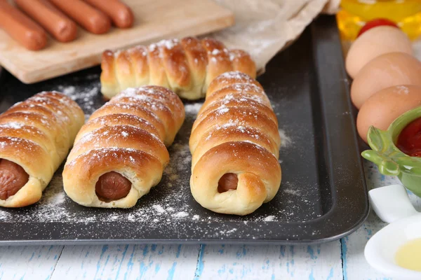 Baked sausage rolls in pan on table close-up — Stock Photo, Image