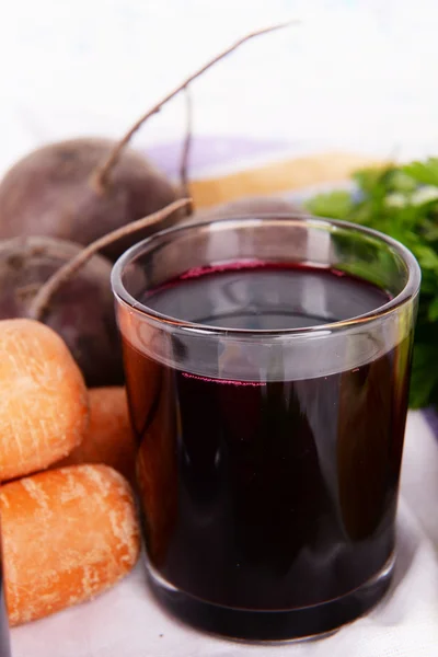 Glass of fresh beet juice and vegetables on table close up — Stock Photo, Image