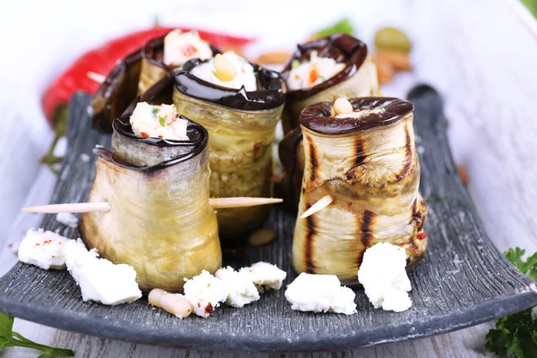 Gebakken aubergine met cottage kaas in een vierkant bord op houten achtergrond — Stockfoto