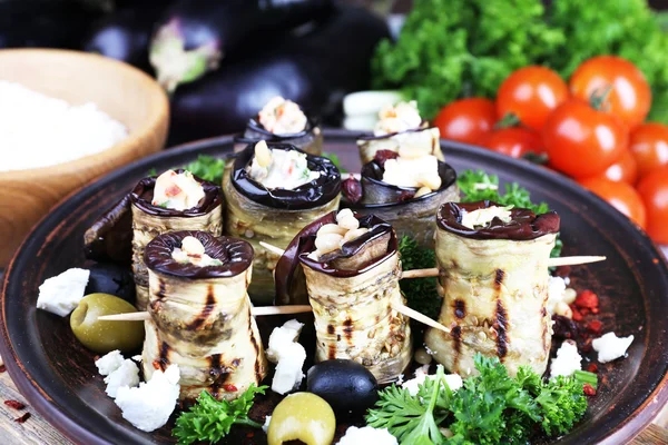 Fried aubergine with cottage cheese in a round plate on wooden cutting board on wooden background — Stock Photo, Image