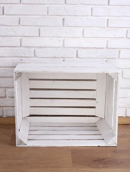 Wooden box on white brick wall background — Stock Photo, Image