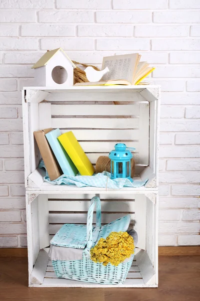 Caixas de madeira com coisas em casa no fundo da parede de tijolo branco — Fotografia de Stock