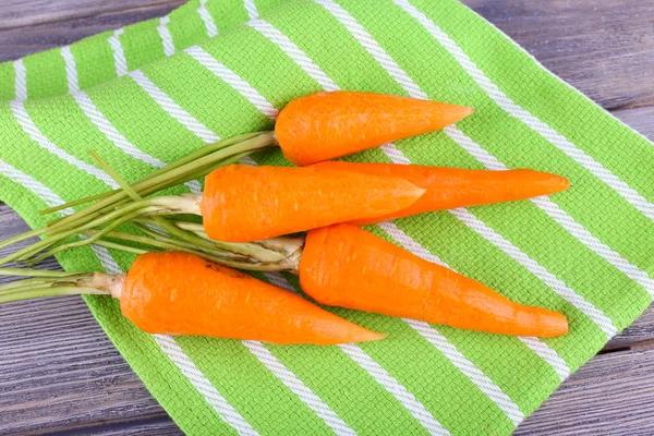 Carrots on napkin on wooden background — Stock Photo, Image