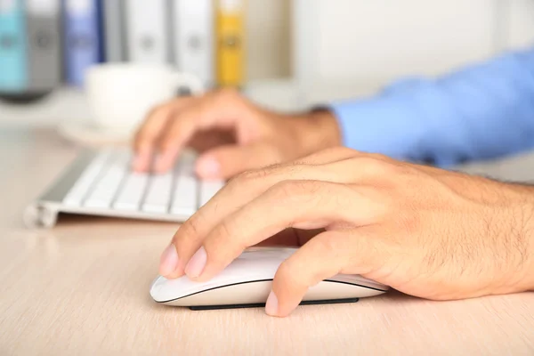 Mann arbeitet mit Tastatur auf Holztisch auf Ordnern Hintergrund Nahaufnahme — Stockfoto