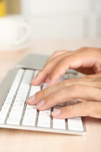 Homem trabalhando com teclado na mesa de madeira closeup — Fotografia de Stock
