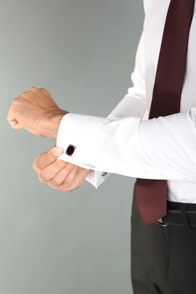 Man doing collar button up on grey background — Stock Photo, Image