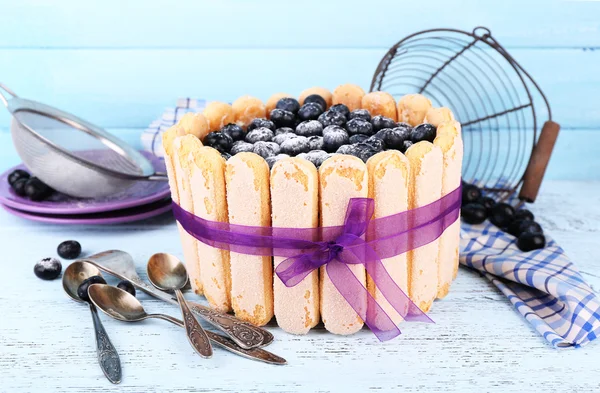 Tasty cake Charlotte with blueberries on blue wooden table — Stock Photo, Image