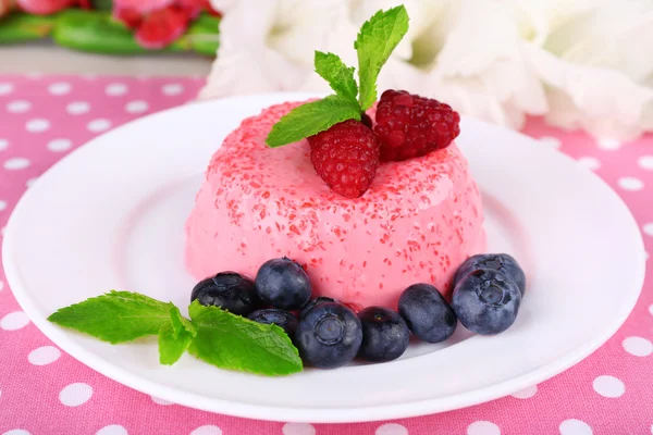 Круглый торт с ягодами на тарелке на скатерти в горошек — стоковое фото