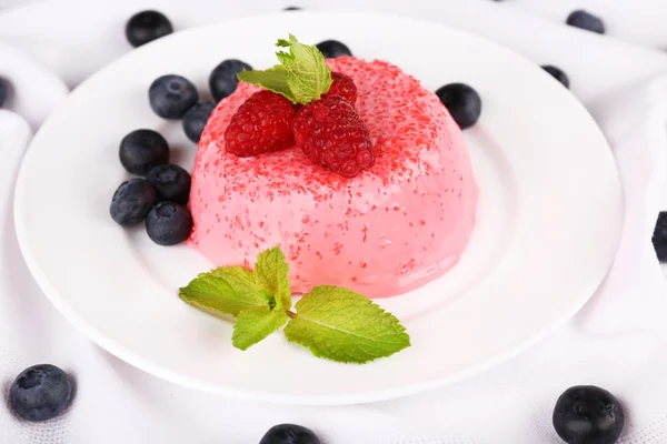 Runde Torte mit Beeren auf Teller auf Tischdecke — Stockfoto