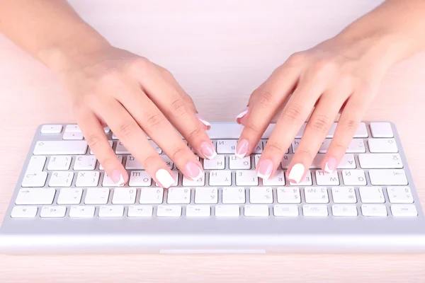 Mãos femininas digitando no teclado, close-up, no fundo claro — Fotografia de Stock