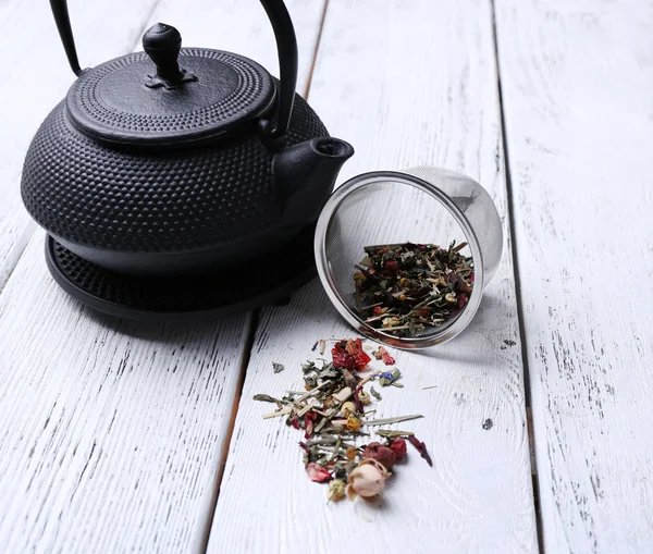 Black teapot, bowl and tea on color wooden background — Stock Photo, Image