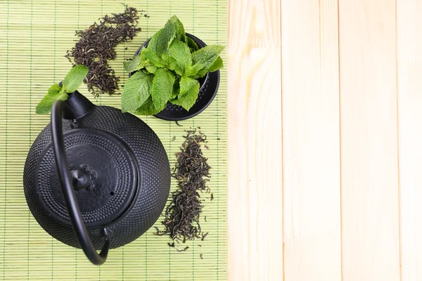 Teko teh tradisional China dengan daun mint segar dengan latar belakang kayu — Stok Foto