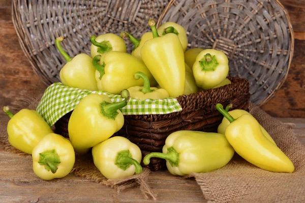 Yellow peppers in basket on wicker background — Stock Photo, Image