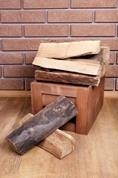 Caja de madera de leña en el suelo sobre fondo de ladrillo —  Fotos de Stock