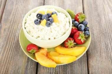 meyve ve çilek ahşap masa üzerinde kase süzme peynir  