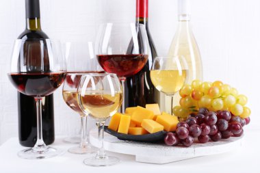 şişe ve kadeh şarap, peynir ve olgunlaşmış üzümler odasındaki masada