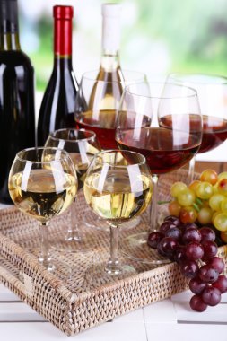şişe ve bardak şarap ve doğal zemin üzerine masada olgunlaşmış üzümler
