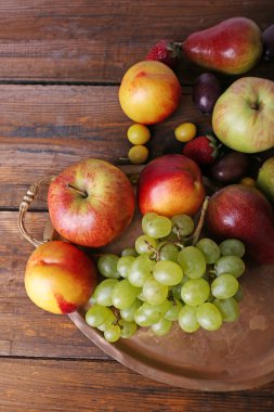 farklı meyveler ve meyve tepsi üzerinde ahşap masa yakın çekim