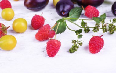 güzel olgun Erik ve ahşap masa yakın çekim üzerinde çilek