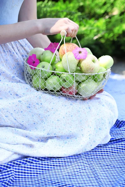 Niña sosteniendo cesta de manzanas al aire libre —  Fotos de Stock