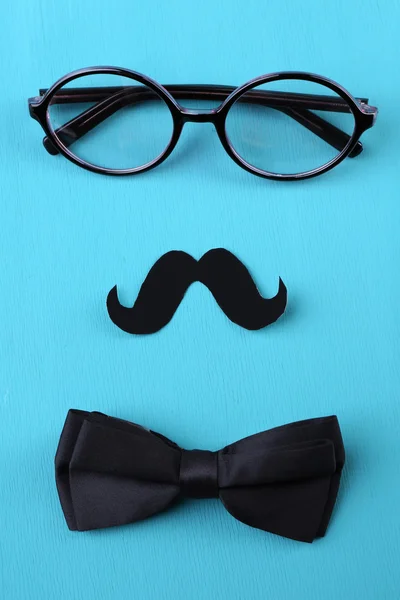 Glasögon, mustasch och fluga bildar man ansikte på färgbakgrund — Stockfoto