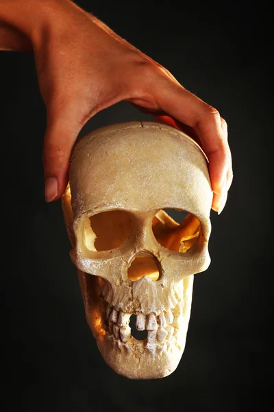 Human skull in hand on dark background — Stock Photo, Image